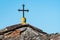 Small cross made of iron on the roof of a small chapel