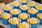 Small cupcakes with yellow cream on the top placed in a blue packing