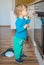 Small and curious child playing with the knobs of the oven in the kitchen. Danger for unattended children, accident prevention at