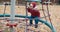 Small, cute child rides on a swing in the yard on a walk with his parents