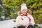 Small cute girl sitting and holding snowman\'s head