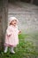 Small cute girl standing near old wall