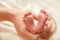 The Small Cute Soles of Newborn Feets are in the Father\'s Hands.