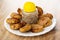 Small cutlets and pepper shaker in white plate on wooden table