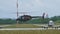 Small dark green camouflage military helicopter flying at low altitude