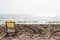 Small deck chair on the sand of a beach with the sea