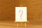 Small decorative easel with question mark or for edit. Illustration of creative crisis