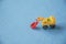 Small decorative toy excavator on blue background. Macro abstract photo. Construction, mining, construction equipment at