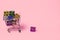 Small decorative trolley with present boxes on bright colorful background. Christmas or birthday gift. Sales and shopping concept