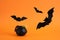 small decorative witch cauldron, gummy worms, spiders, cobwebs and bats on orange background, halloween background