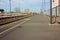 A small deserted local station during the day. sidewalk for waiting passengers waiting for trains for their journeys, between