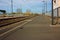 A small deserted local station during the day. sidewalk for waiting passengers waiting for trains for their journeys, between