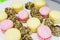 Small desserts for guests on a plate. Macaroons and small cakes. Soft selective focus on cakes.