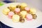 Small desserts for guests on a plate. Macaroons and small cakes. Soft selective focus on cakes.