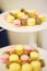 Small desserts for guests on a plate. Macaroons and small cakes. Soft selective focus on cakes.