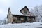 Small dilapidated abandoned house covered with fresh snow