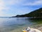 A small dinghy sitting long the beaches of an island with beautiful clear water in the background and many boats anchored