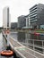 A small dingy moored on the jetty at leeds dock with surrounding apartment buildings and clarence house building