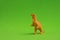 Small dinosaur toy on a green background