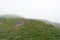 Small distant figure of unregognisable person on hilltop in fog