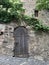 Small door to the city medieval castle made of old stone above a summer park, tourist, historical concept, architecture of