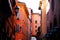 Small downtown street with colorful houses of red in Bologna in Emilia Romagna (Italy)