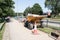 Small dumper truck parked at the side of sidewalk pavement in street