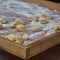 Small Dumplings on Wooden Board with Flour: Italian Gnocchi Pasta