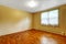 Small empty basement room with hardwood floor and beige walls