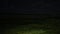 Small empty green field in the night, with sky and forest