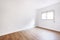 Small empty living room chestnut hardwood floors and double-hung aluminum windows