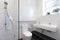Small ensuite bathroom with white tiling laid in brick pattern