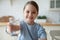 Small european child girl offering glass with fresh aqua.