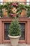 Small evergreen in planter with wreath used as decor in front of random home