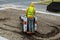 A small excavator works on the street in the summer