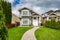 Small family house with curved concrete pathway over green lawn on front yard