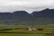 Small farm among green hills in Iceland