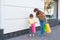 Small fashionable girl and mom looking at purchases in shopping bags