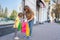 Small fashionable girl and mom looking at purchases in shopping bags