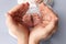Small feet of a newborn in the hands of parents. Loving palms of hands of mother