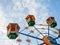 A small Ferris wheel in the park. A bright attraction for children. Entertainment in the park. Colorful booths. High above the