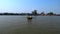 A small ferry boat crosses the Chao Phraya River