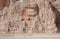 Small figure of woman walking past the historical monuments of Naqsh-e Rustam