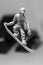 Small figurine of a surfer riding a board on a gray background