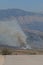 Small fire in valley fire view from hill above Saranda city in Albania