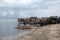 Small fishing boat anchored beside the over water stilt Bajau shanty houses. Long shot