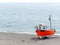 Small fishing boat beached on land with ocean in the background