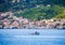 small fishing boat crossing the blue waters opposite the beautiful island of Spetses, located in Saronikos gulf near Athens