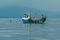 Small Fishing Boat With Lobster Pods And Seagulls On Calm Atlantic In Front Of The Hebride Islands