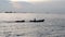 Small fishing boat of local people moving in the sea with wave behind.